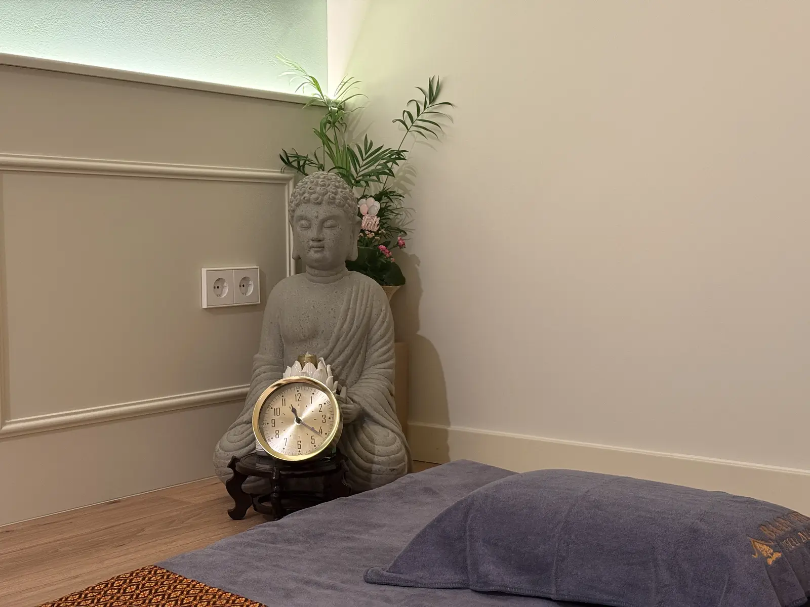 Estatua de Buda con reloj en la sala de masaje tailandés Baan Pho Girona